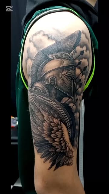 Crisp professional photograph of a finished phoenix tattoo on shoulder and forearm, intricate blackwork with delicate red ember ink accents, soft studio lighting, sharp detail, artistic dark backdrop